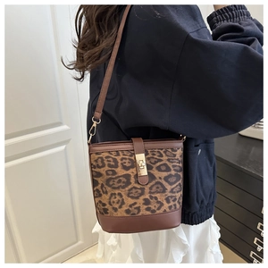 Détail du sac seau léopard avec finitions en cuir marron et fermoir carré doré brillant