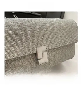Close-up of sparkling silver sequin fabric and metal twist lock on a shoulder bag