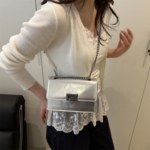 Minimalist silver chain shoulder bag for women styled with white knitwear and dark trousers