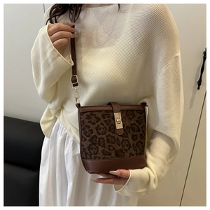Vue détaillée du sac seau léopard avec bordure en cuir marron et boucle dorée chic