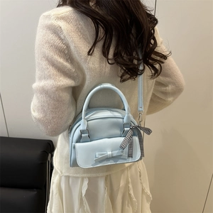 Fashionable light blue leather tote bag with bow detail and plaid ribbon on handle