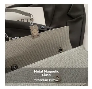 Close-up of the metallic silver bag showing the magnetic buckle closure detail
