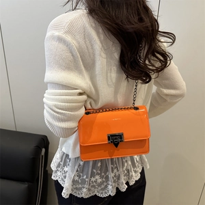 Chic orange patent leather crossbody bag with black metal chain strap and flap closure