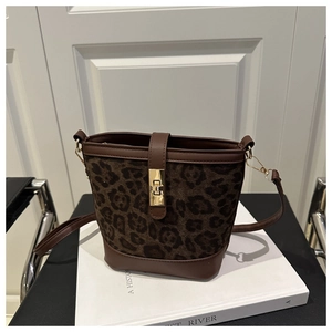 Détail d'un sac seau léopard avec fermoir en métal doré et bandoulière en cuir