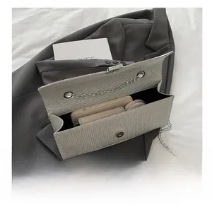 Internal storage display of minimalist textured flap bag with chain strap and magnetic snap