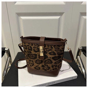 Détail du sac seau à motif léopard avec bordures en cuir et fermoir doré rotatif