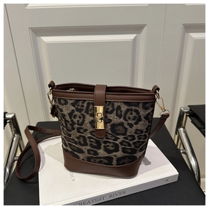 Détail du sac seau léopard avec fermoir rotatif en métal doré et bordure en cuir