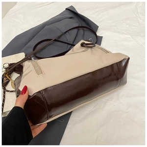 Détail d'un sac rétro bicolore en cuir brillant marron avec finitions zippées latérales