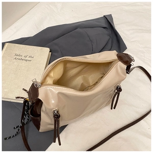 Détail d'un sac cabas beige et marron montrant la fermeture éclair et le compartiment intérieur