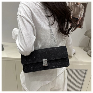 Detail view of a black glitter crossbody bag with silver chain strap and metal buckle