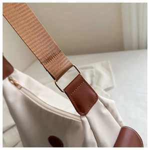 Nahaufnahme der beigen Nylon-Einkaufstasche mit braunem Leder und Goldbeschlägen
