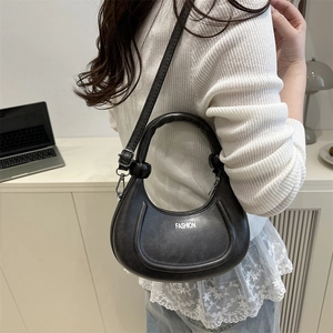 Chic black crescent moon handbag with FASHION lettering and adjustable shoulder strap