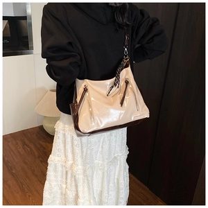 Détail du sac cabas beige et marron avec finition brillante et doubles fermetures éclair