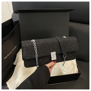 Close-up of black sequined evening clutch bag with silver chain and geometric clasp