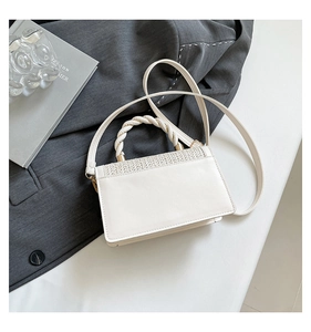 Detail of white PU leather handbag with beige woven texture lid and twisted handle