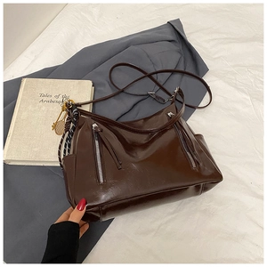Détail du grand sac cabas marron brillant avec pendentif raquette de tennis en métal