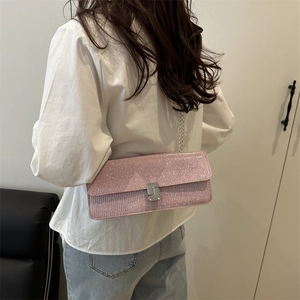 Chic pink glitter crossbody bag with silver chain strap shown on model's shoulder