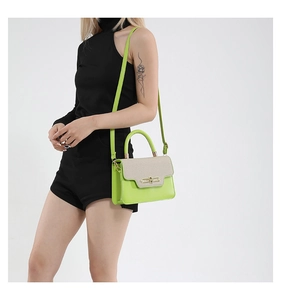 Detail of neon green crossbody bag with cream woven flap and gold oval hardware