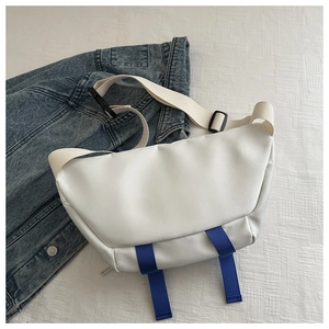 Detailed view of white crossbody bag with blue vertical webbing and adjustable shoulder strap
