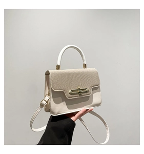 Detail of woven khaki fabric and beige leather handbag with golden twist lock