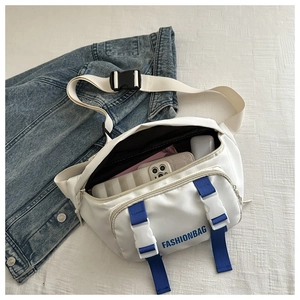 Detailed view of white canvas crossbody bag with blue straps and plastic buckle