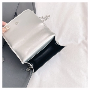 Interior detail of silver mini bag with black fabric lining and magnetic snap closure