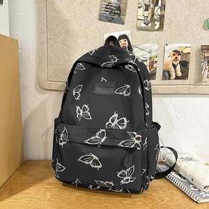 Close-up of lightweight black backpack with white butterfly patterns and side pocket detail