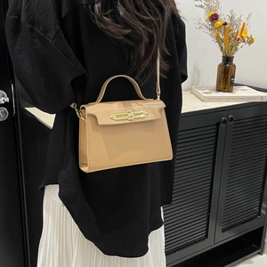 Classic camel leather trapezoid handbag with gold metal clasp on modern marble background