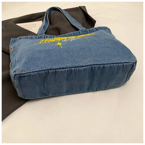 Detail of denim tote bag with yellow Trippy star embroidery and wide base