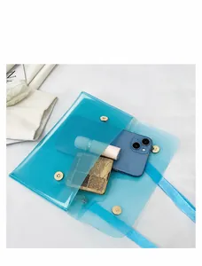 Detailansicht der blauen transparenten PVC Tasche mit Inhalt und Magnetverschluss