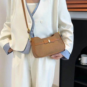 Minimalist brown woven crossbody bag with bow detail and leather strap on model