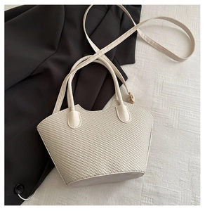 Détail du sac seau tissé blanc cassé avec poignées et bandoulière réglable