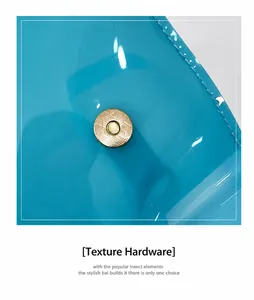 Detail der hellblauen transparenten PVC-Tasche mit goldenem Magnetverschluss und Textur