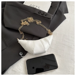 Detailed close-up of a mini white croissant bag with a gold chain and quilted texture