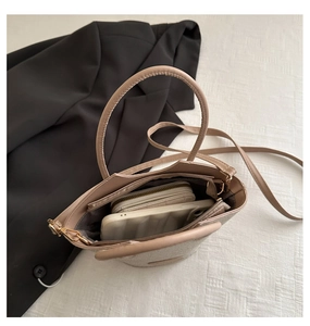 Détail du sac seau tissé beige montrant l'intérieur spacieux pour téléphone et portefeuille