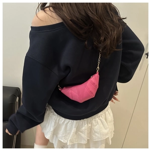 Detailed view of rose pink croissant crossbody bag with quilted texture and chain strap
