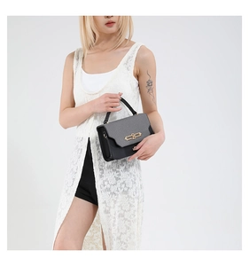 Detail of the gray textured flap with golden twist lock on this stylish crossbody bag