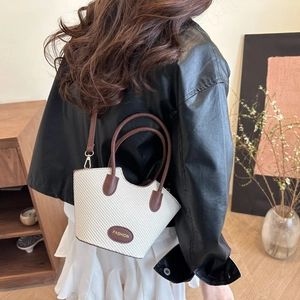 Sac seau tissé élégant en beige avec des lanières et poignées en cuir marron foncé