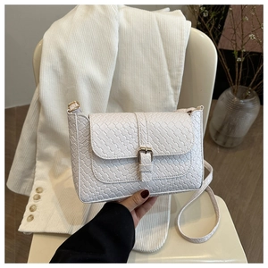 Detailed close-up of a white woven texture crossbody bag with elegant gold buckle
