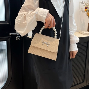 Glittery champagne crossbody bag with pearl handle and metal bow decoration