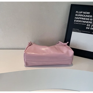 Detailed view of the pink glossy patent leather tote bag with unique knot side accents