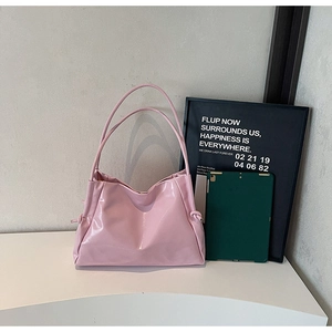 Detail view of pink patent leather tote bag with stylish side knots and dual straps