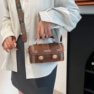 Elegant brown bucket handbag with gold buckles and patterned shoulder strap for women