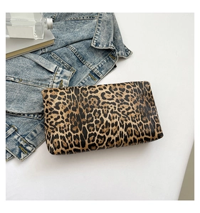 Flat lay of a leopard print clutch bag paired with denim jacket and accessories