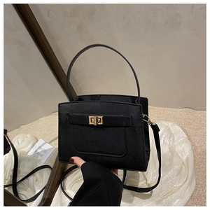 Detailed close-up of a black Saffiano leather tote bag featuring a gold turn-lock closure
