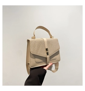 Détail du sac crème montrant la texture du rabat tissé et la large bandoulière
