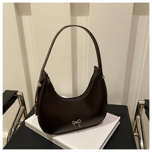Détail d'un sac hobo en cuir marron foncé avec un petit nœud métallique argenté chic