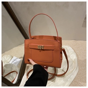 Detail of orange Saffiano tote bag with golden twist lock and adjustable shoulder strap