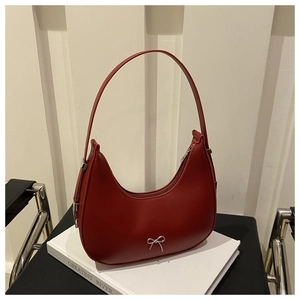 Détail du sac demi-lune rouge vintage avec un nœud métallique argenté élégant
