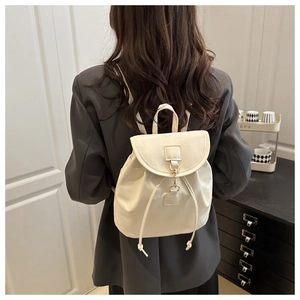 Detail of cream white faux leather backpack with drawstring closure and metal hook